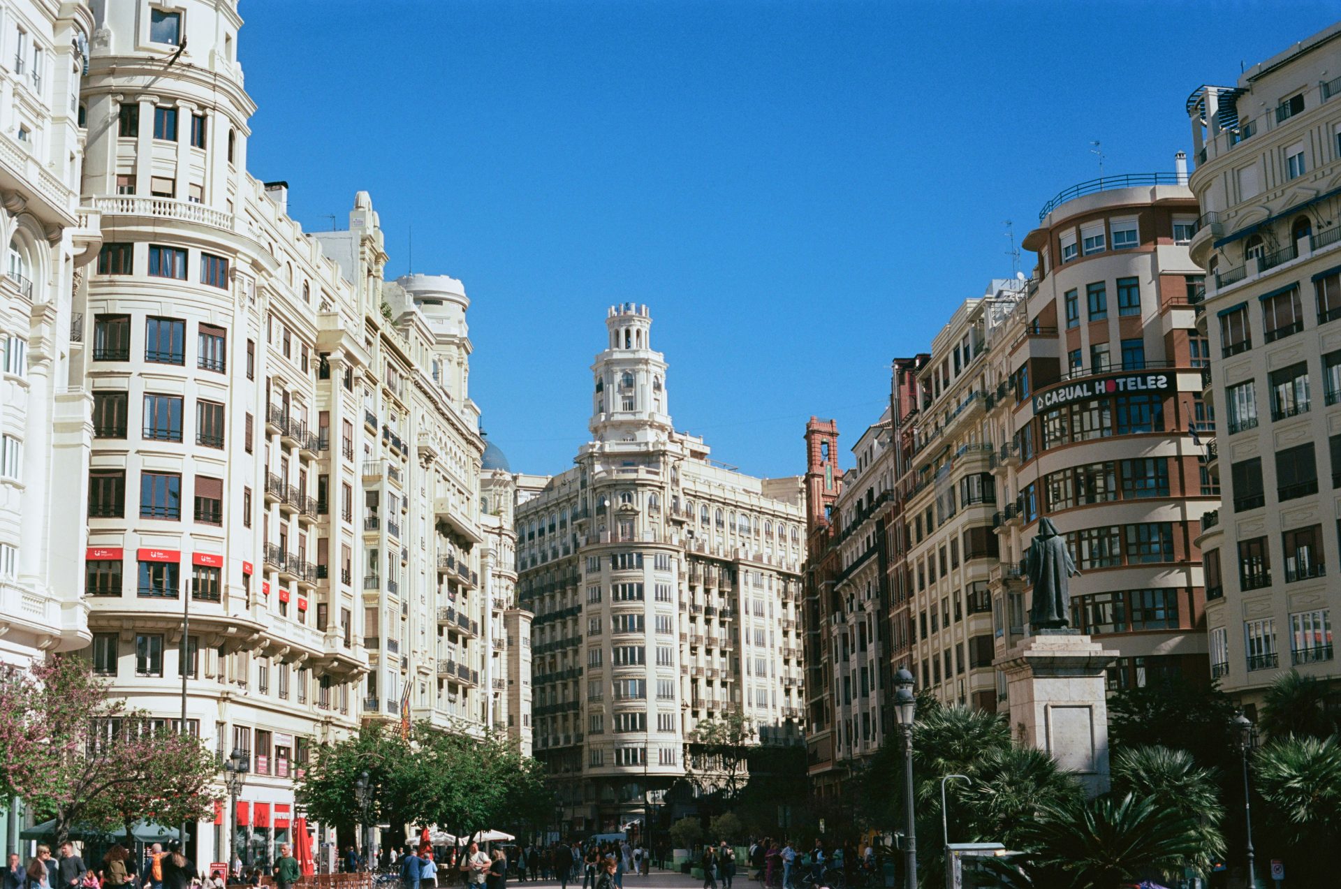 Elegant buildings line a sunny city street.